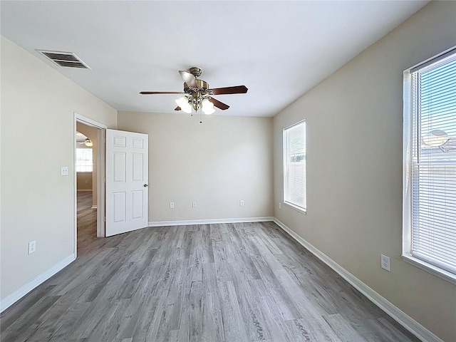 2409 E Magnolia St, Lakeland, FL 33801 - unfurnished room with plenty of natural light, wood finished floors, ceiling fan, and baseboards
