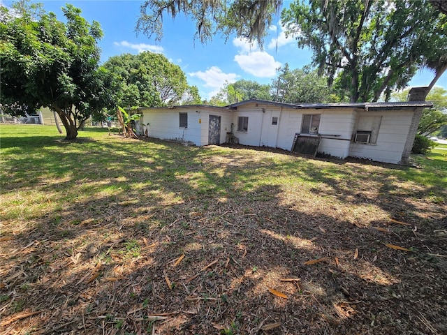 2704 Sample St, Kissimmee, FL 34744 - rear view of house featuring a chimney and a lawn
