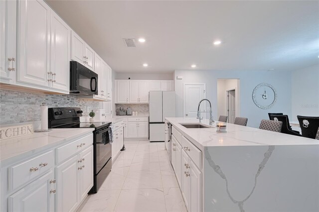 454 Hamlet Loop, Davenport, FL 33837 - kitchen featuring black appliances, a sink, a kitchen island with sink, light marble finish flooring, and backsplash