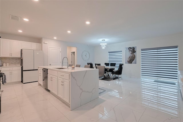 454 Hamlet Loop, Davenport, FL 33837 - kitchen with freestanding refrigerator, a sink, dishwasher, light marble finish floors, and white cabinetry