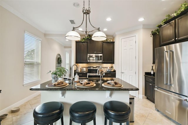 1703 Encinitas Way, Kissimmee, FL 34759 - kitchen with stainless steel appliances, light tile patterned floors, dark brown cabinetry, a breakfast bar area, and ornamental molding