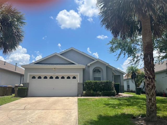 123 S Roma Way, Kissimmee, FL 34746 - ranch-style house with concrete driveway, stucco siding, a front lawn, a garage, and brick siding
