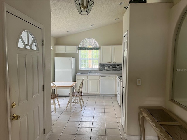 123 S Roma Way, Kissimmee, FL 34746 - kitchen with white appliances, a textured ceiling, a sink, lofted ceiling, and white cabinetry