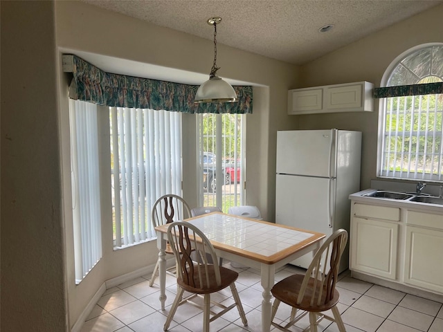 123 S Roma Way, Kissimmee, FL 34746 - dining room featuring healthy amount of natural light, light tile patterned floors, a textured ceiling, and baseboards