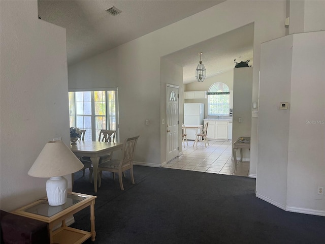 123 S Roma Way, Kissimmee, FL 34746 - carpeted dining area with vaulted ceiling, baseboards, tile patterned floors, and a textured ceiling