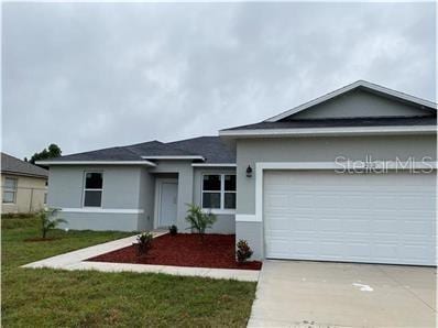 212 Grouper Ct, Poinciana, FL 34759 - ranch-style house featuring stucco siding, driveway, a garage, and a front yard