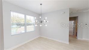 212 Grouper Ct, Poinciana, FL 34759 - unfurnished dining area featuring a chandelier and baseboards