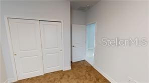 212 Grouper Ct, Poinciana, FL 34759 - unfurnished bedroom featuring a closet and baseboards