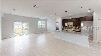 212 Grouper Ct, Poinciana, FL 34759 - unfurnished living room featuring a sink, light tile patterned floors, baseboards, and recessed lighting