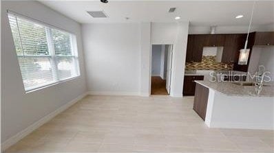 212 Grouper Ct, Poinciana, FL 34759 - kitchen with light countertops, backsplash, baseboards, a sink, and recessed lighting