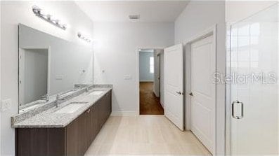 212 Grouper Ct, Poinciana, FL 34759 - bathroom with double vanity, a shower stall, and baseboards