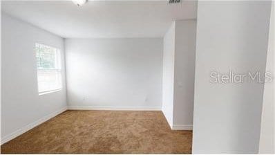 212 Grouper Ct, Poinciana, FL 34759 - carpeted spare room featuring baseboards