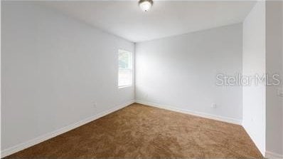 212 Grouper Ct, Poinciana, FL 34759 - spare room with carpet flooring and baseboards