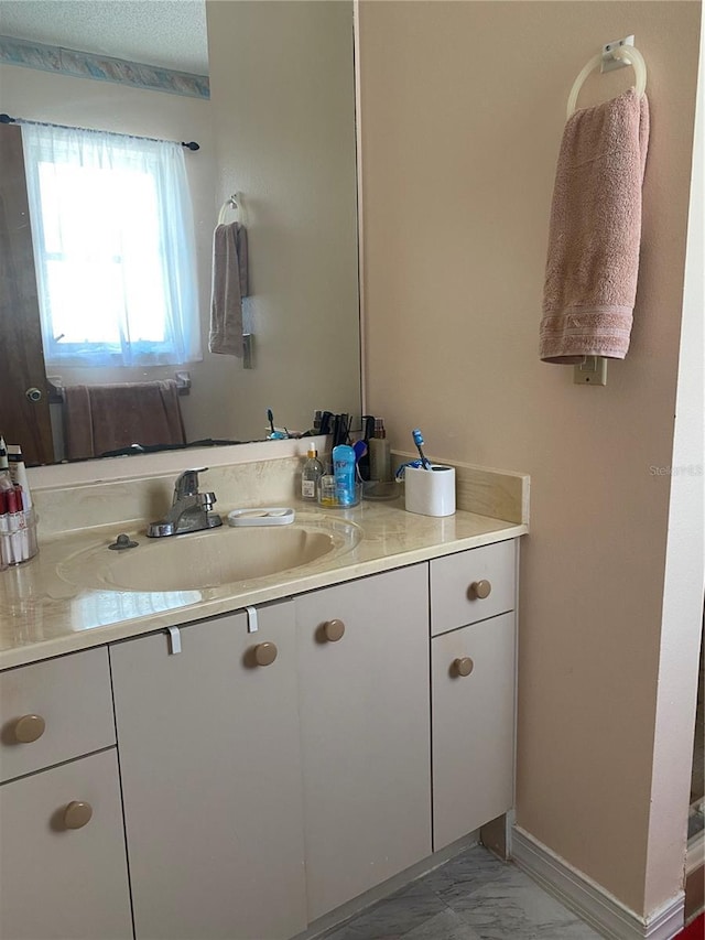 12322 Alta Mira St, North Port, FL 34287 - bathroom with vanity, marble look tiles, and baseboards