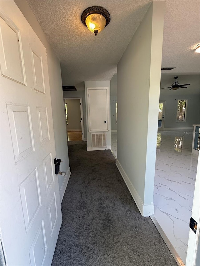 6489 Creation St, Saint Cloud, FL 34771 - corridor with a textured ceiling, baseboards, marble finish floors, and carpet