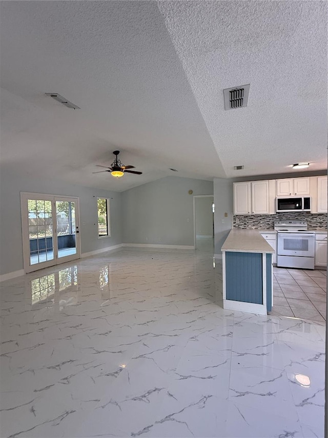 6489 Creation St, Saint Cloud, FL 34771 - kitchen with white electric range, stainless steel microwave, open floor plan, baseboards, and a textured ceiling