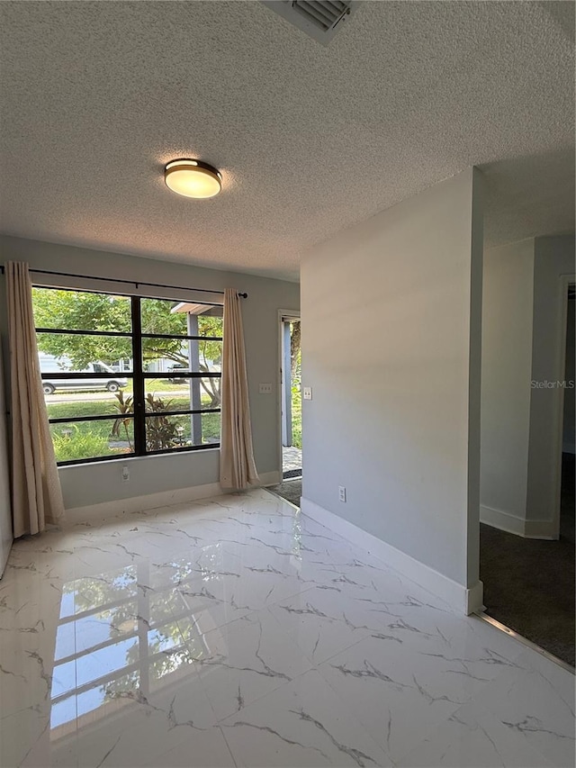 6489 Creation St, Saint Cloud, FL 34771 - spare room with marble look tiles, baseboards, and a textured ceiling