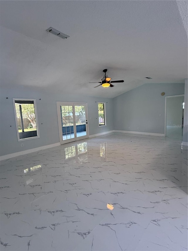 6489 Creation St, Saint Cloud, FL 34771 - empty room featuring plenty of natural light, baseboards, a ceiling fan, a textured ceiling, and lofted ceiling