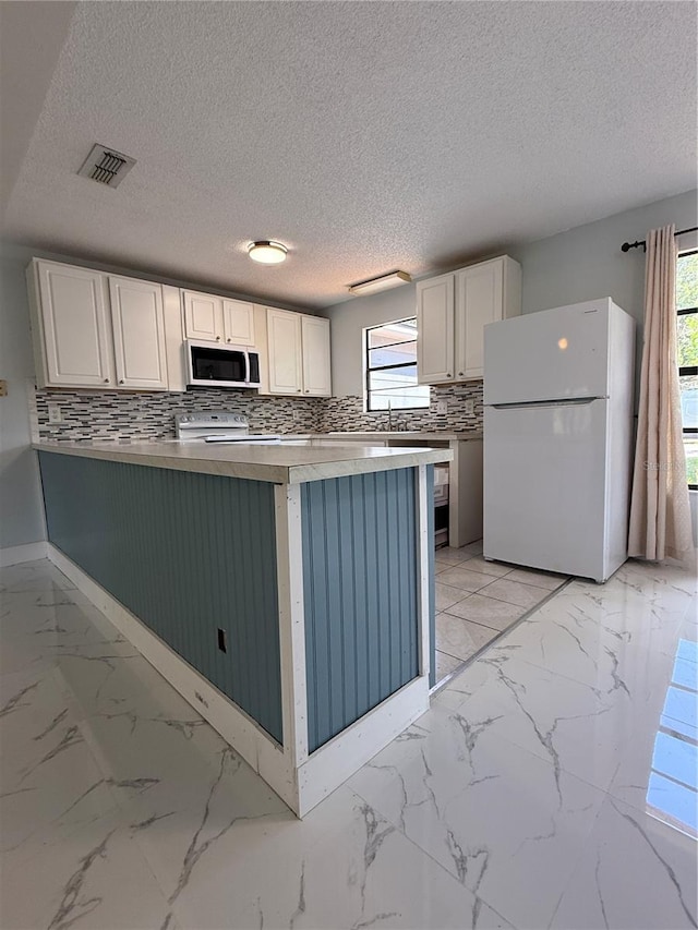 6489 Creation St, Saint Cloud, FL 34771 - kitchen featuring freestanding refrigerator, electric range, healthy amount of natural light, decorative backsplash, and a textured ceiling