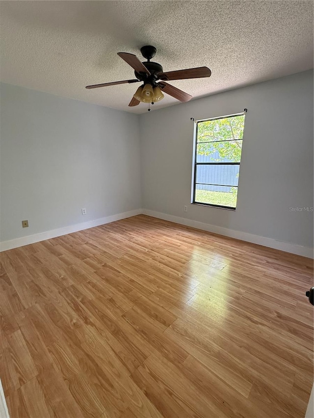 6489 Creation St, Saint Cloud, FL 34771 - unfurnished room featuring light wood-style flooring, a textured ceiling, ceiling fan, and baseboards