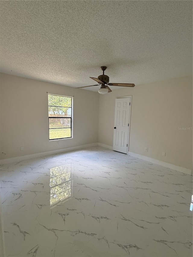 6489 Creation St, Saint Cloud, FL 34771 - spare room featuring light marble finish flooring, ceiling fan, a textured ceiling, and baseboards