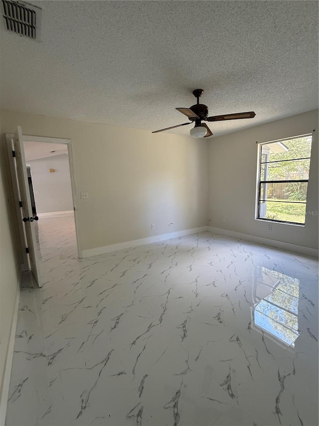 6489 Creation St, Saint Cloud, FL 34771 - unfurnished room with baseboards, ceiling fan, a textured ceiling, and light marble finish flooring