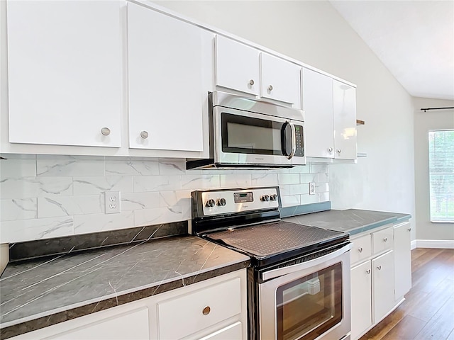 30 Lake Diamond Ave, Ocala, FL 34472 - kitchen featuring appliances with stainless steel finishes, vaulted ceiling, white cabinetry, and backsplash