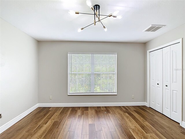 30 Lake Diamond Ave, Ocala, FL 34472 - unfurnished bedroom with a chandelier, baseboards, wood finished floors, and a closet