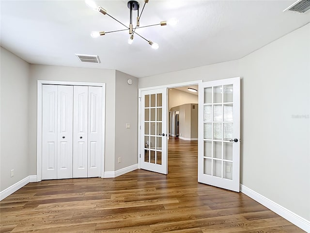 30 Lake Diamond Ave, Ocala, FL 34472 - unfurnished bedroom with french doors, a chandelier, wood finished floors, and baseboards