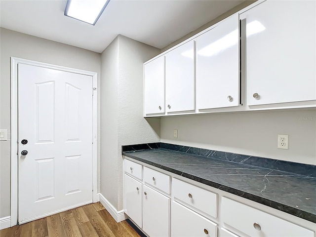 30 Lake Diamond Ave, Ocala, FL 34472 - kitchen with wood finished floors, dark countertops, white cabinetry, and baseboards