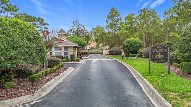 30 Lake Diamond Ave, Ocala, FL 34472 - view of asphalt road featuring curbs, a gated entry, and a gate