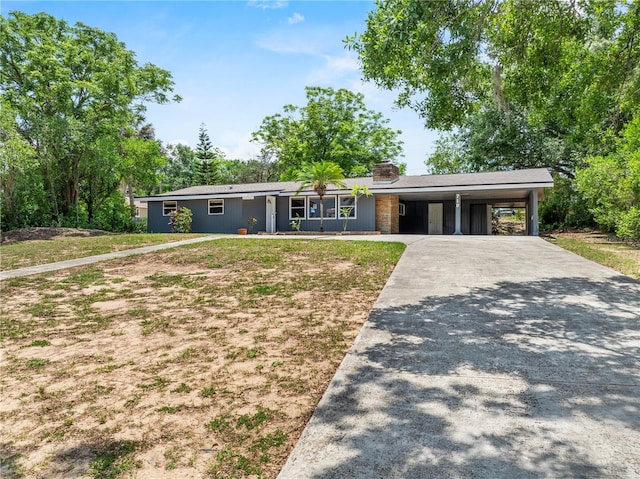 710 Carlton Ave, Lake Wales, FL 33853 - view of front of house featuring concrete driveway, a chimney, a carport, and a front yard