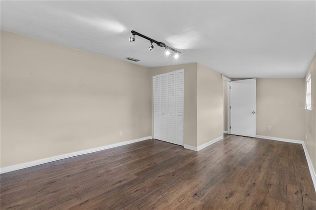 710 Carlton Ave, Lake Wales, FL 33853 - unfurnished room featuring rail lighting, dark wood-style floors, and baseboards