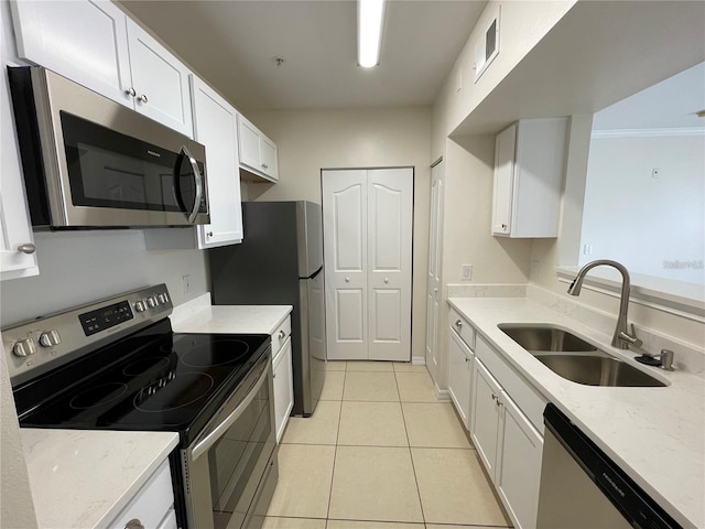 1020 Siena Park Blvd W Unit 304, Kissimmee, FL 34747 - kitchen with stainless steel appliances, a sink, white cabinets, light tile patterned floors, and light stone countertops