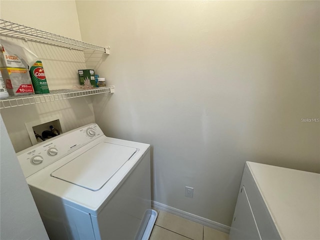 1020 Siena Park Blvd W Unit 304, Kissimmee, FL 34747 - laundry area featuring tile patterned flooring, baseboards, and separate washer and dryer
