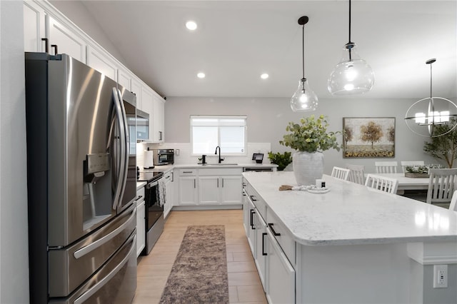 3211 Sweet Acres Pl, Saint Cloud, FL 34772 - kitchen with stainless steel appliances, a sink, a center island, recessed lighting, and white cabinetry
