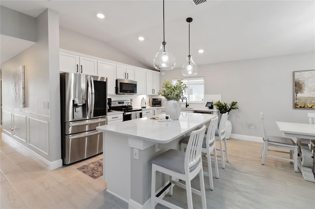 3211 Sweet Acres Pl, Saint Cloud, FL 34772 - kitchen with appliances with stainless steel finishes, a sink, a center island, white cabinetry, and a breakfast bar area