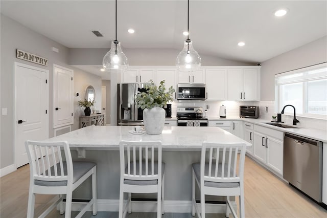 3211 Sweet Acres Pl, Saint Cloud, FL 34772 - kitchen with appliances with stainless steel finishes, a sink, backsplash, a center island, and white cabinets