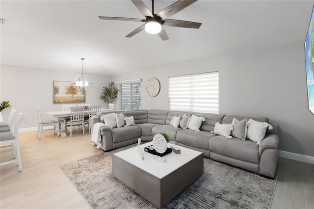 3211 Sweet Acres Pl, Saint Cloud, FL 34772 - living room featuring ceiling fan, a chandelier, wood finished floors, and baseboards