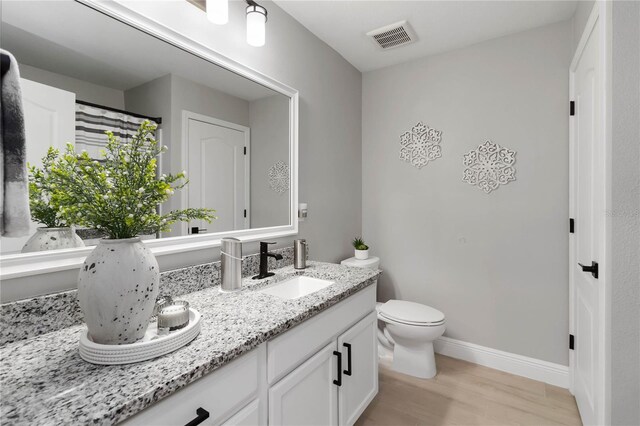 3211 Sweet Acres Pl, Saint Cloud, FL 34772 - full bath with double vanity, baseboards, toilet, and wood finished floors