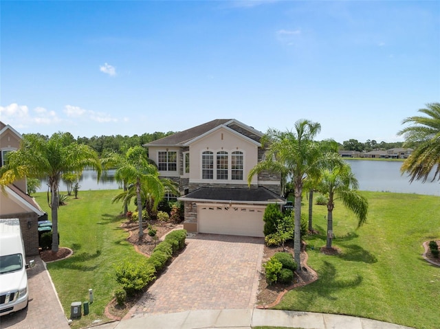 15037 Cedar Branch Way, Orlando, FL 32824 - traditional-style house featuring a water view, an attached garage, decorative driveway, a front yard, and stucco siding