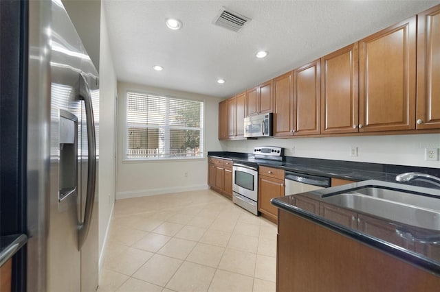 7468 Excitement Dr Unit 101, Reunion, FL 34747 - kitchen featuring stainless steel appliances, recessed lighting, baseboards, light tile patterned floors, and a sink