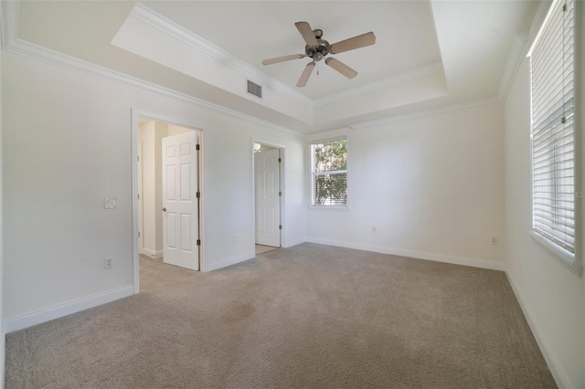 7468 Excitement Dr Unit 101, Reunion, FL 34747 - unfurnished bedroom featuring a tray ceiling, light colored carpet, crown molding, baseboards, and ceiling fan