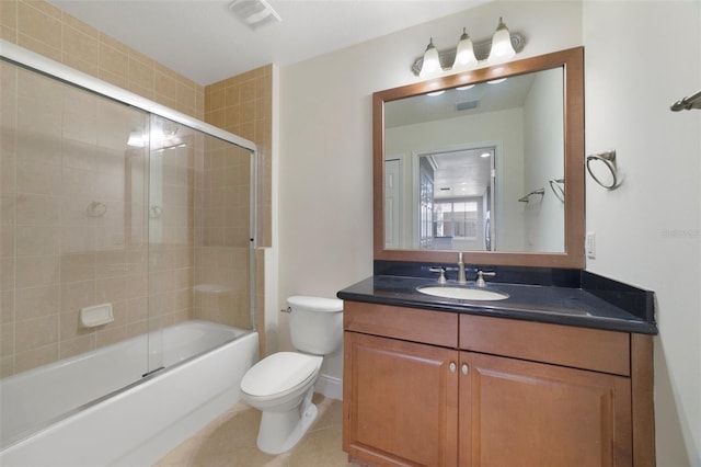7468 Excitement Dr Unit 101, Reunion, FL 34747 - bathroom featuring toilet, vanity, enclosed tub / shower combo, tile patterned floors, and baseboards