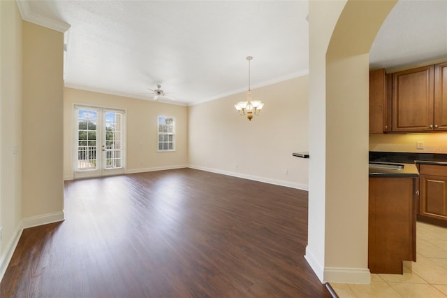 1501 Northern Harrier Way Unit 202, Reunion, FL 34747 - unfurnished living room with a ceiling fan, arched walkways, crown molding, light wood-style flooring, and baseboards