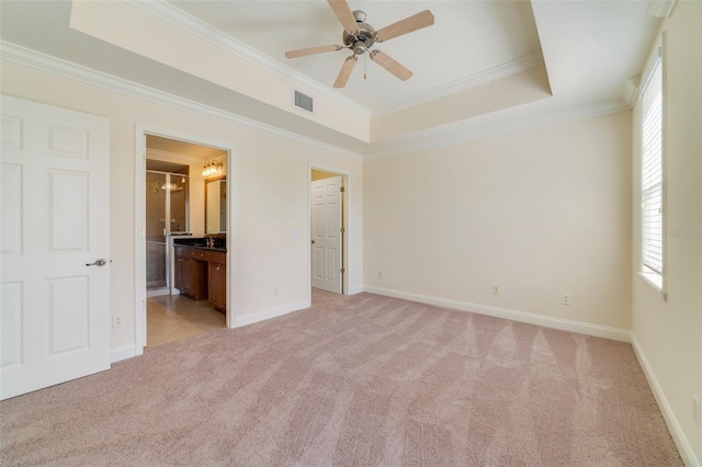 1501 Northern Harrier Way Unit 202, Reunion, FL 34747 - unfurnished bedroom featuring light colored carpet, ornamental molding, baseboards, a raised ceiling, and ensuite bath