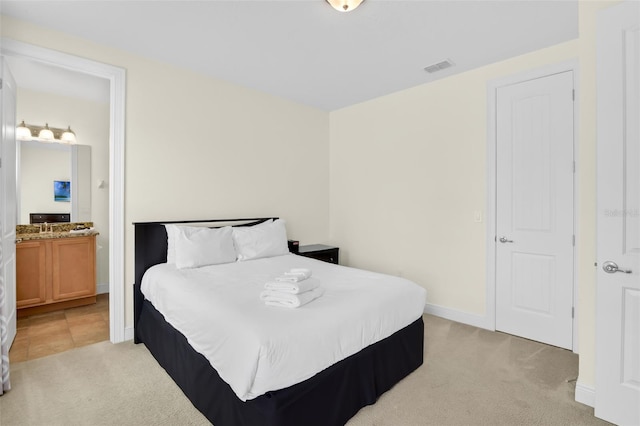 341 Lasso Dr, Kissimmee, FL 34747 - bedroom with light colored carpet, connected bathroom, and baseboards