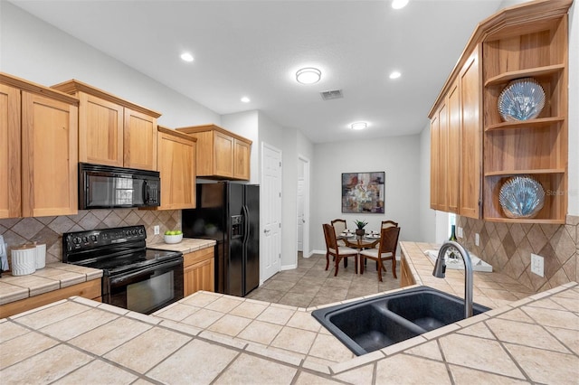 6479 Apple St, Saint Cloud, FL 34771 - kitchen with black appliances, a sink, tile countertops, open shelves, and baseboards