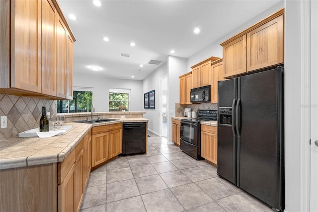 6479 Apple St, Saint Cloud, FL 34771 - kitchen with black appliances, a sink, a peninsula, tasteful backsplash, and tile counters