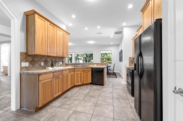 6479 Apple St, Saint Cloud, FL 34771 - kitchen with black appliances, a peninsula, a sink, tasteful backsplash, and recessed lighting